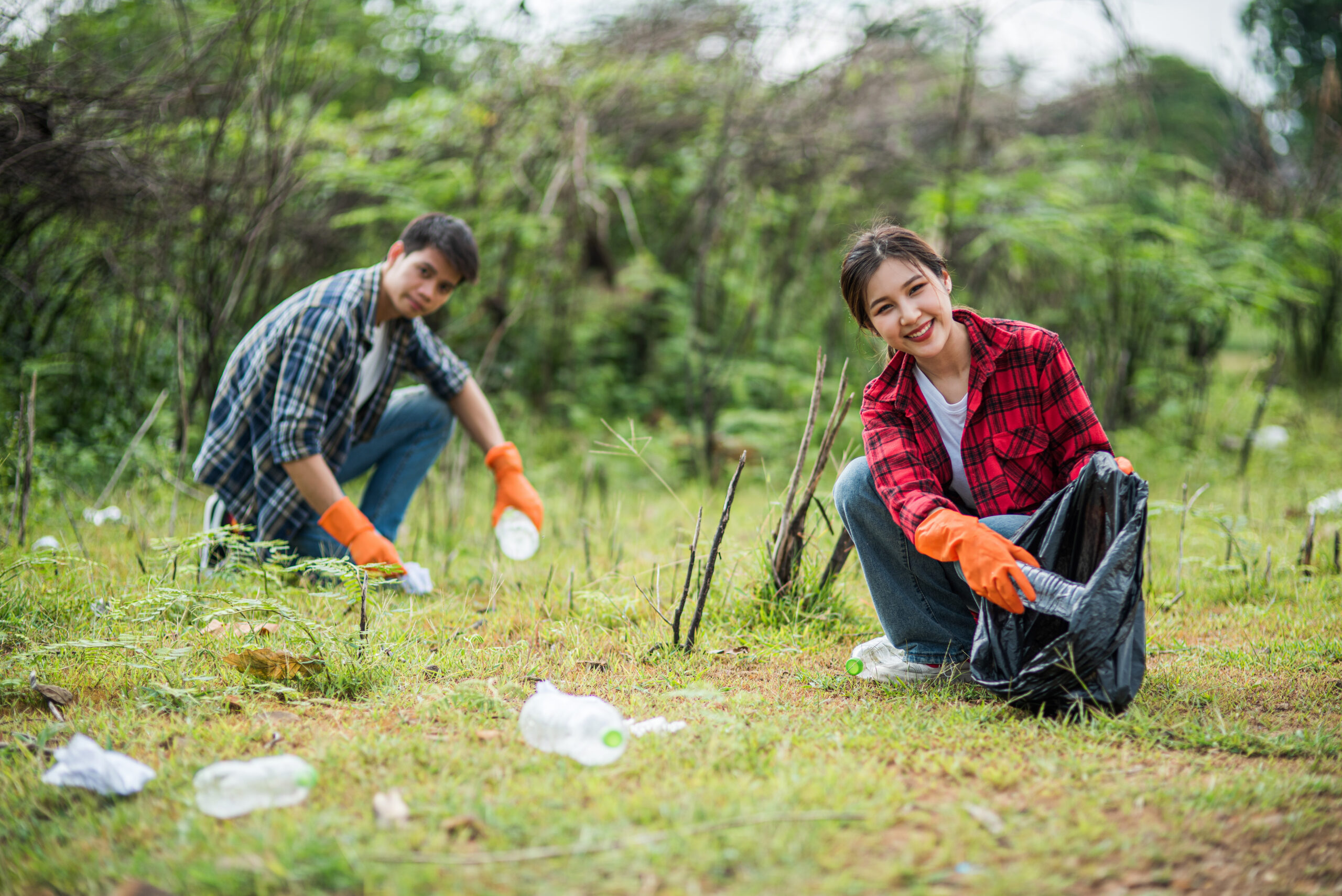 Men and women help each other to collect garbage.